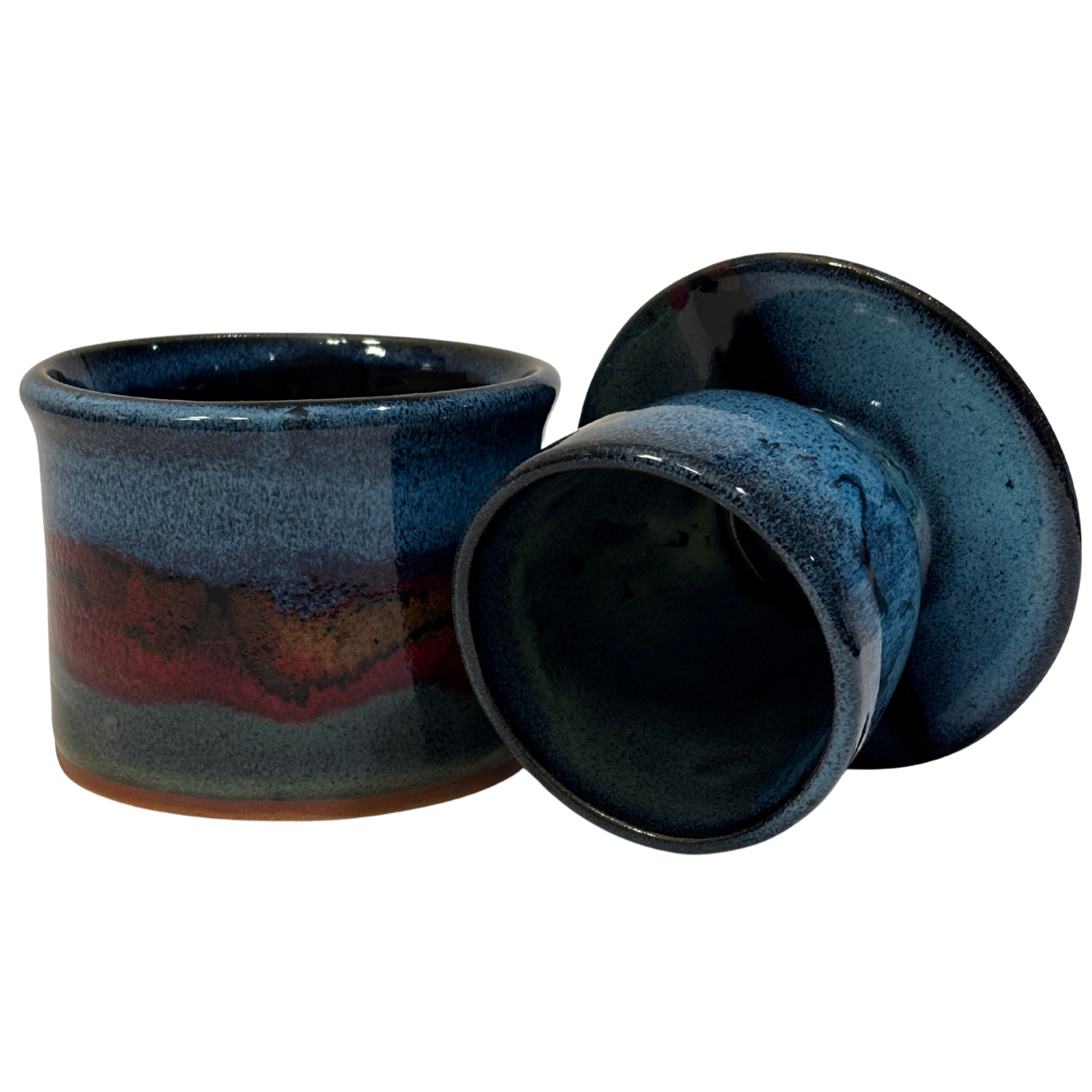 Handmade ceramic French butter press in Artic Twilight glaze with deep blue, red, and earthy tones.