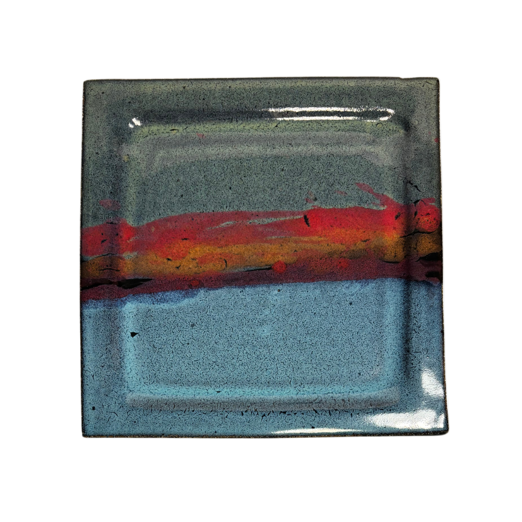 Handcrafted square ceramic dinner plate with layered glaze in blue, red, and black tones – artisan pottery tableware with modern rustic finish.